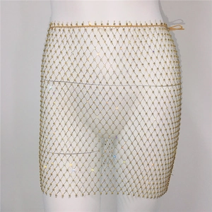 Détail de la jupe en maille dorée scintillante avec des strass sur un mannequin blanc
