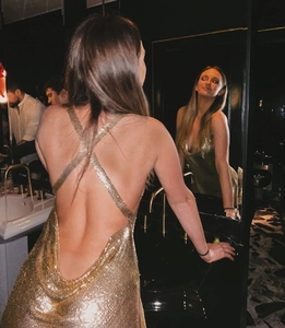 Detail of gold sequin dress featuring open back design and crisscross straps