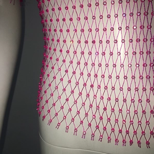 Close-up detail of hot pink fishnet crop top with sparkling rhinestone embellishments