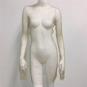 Detail of gold fishnet mini dress featuring sparkling crystal rhinestones and long sleeves
