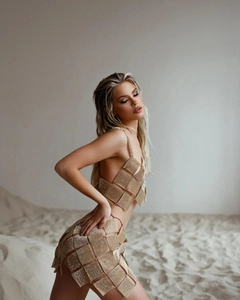 Detail of gold sequin mesh two-piece set featuring backless top and mini skirt for parties
