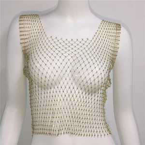 Gros plan sur le gilet en maille dorée orné de strass étincelants sur un mannequin blanc