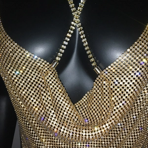 Detailed macro view of sparkling gold rhinestone mesh fabric and metallic chain straps