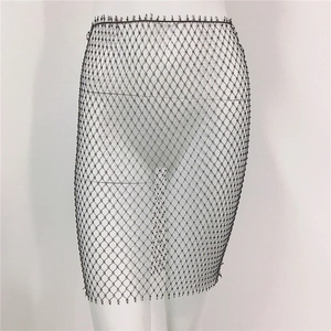 Détail de la mini-jupe en maille noire avec perles argentées et texture élastique fine