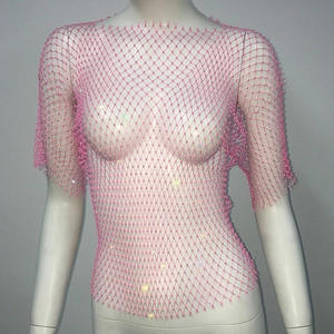Vue détaillée du haut en maille rose avec des strass brillants sur un tissu transparent