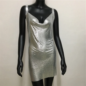 Detailed macro view of silver sequin texture and metallic mesh on a V-neck party dress