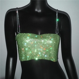 Détail du haut court à strass verts avec chaînes métalliques et sequins scintillants