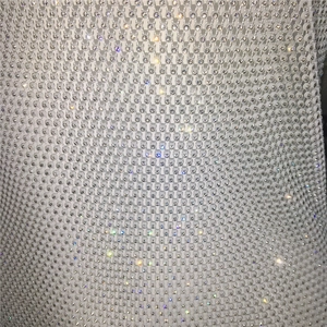 Close-up of fine mesh fabric with densely set sparkling rhinestones on halter dress