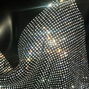Macro shot of high-density silver rhinestones on black fabric for party top