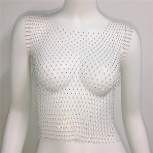 Gros plan d'un haut court en maille blanche de luxe avec des strass étincelants et filet