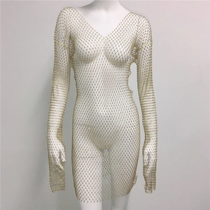 Détail d'une robe en maille dorée à manches longues avec strass brillants et décolleté en V