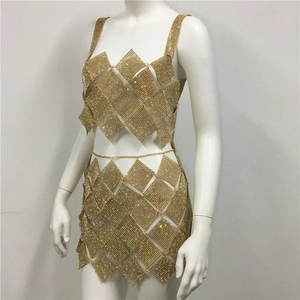 Detailed macro view of the gold rhinestone mesh fabric and craftsmanship of the two-piece dress