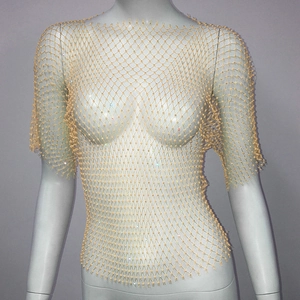 Détail d'un haut en maille dorée avec strass scintillants pour tenue de soirée