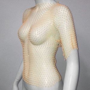 Detail of orange mesh crop top featuring sparkling rhinestones and hollow-out grid texture