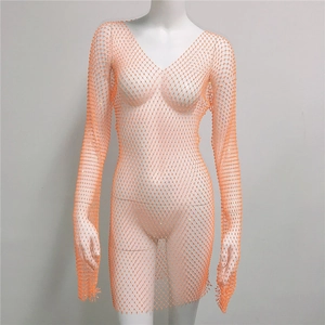 Détail de la robe en résille orange avec strass, manches longues et cristaux brillants