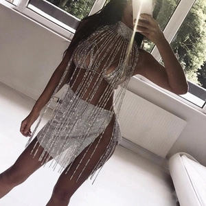 Close-up of sparkling rhinestone tassels on sexy halter crop top and mini skirt outfit