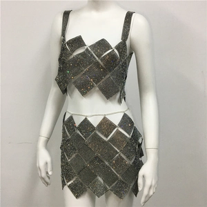 Detailed view of the diamond-shaped rhinestone panels and metal chain links on a dress