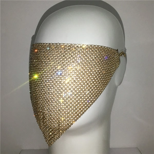 Detailed close-up of golden mesh mask with shimmering rhinestones for parties