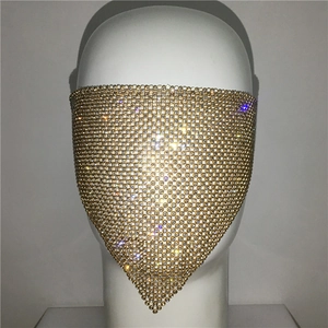 Detailed close-up of golden mesh veil mask encrusted with sparkling white rhinestones