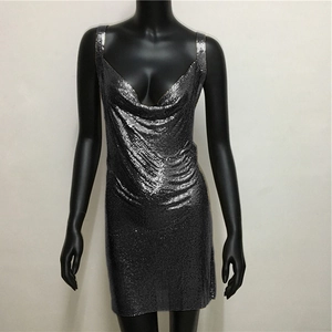 Detail of silver sequin mini dress showing the metallic mesh texture and deep V-neckline