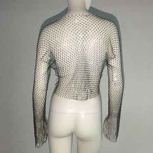 Close-up of sparkling colorful rhinestones on black fishnet mesh crop top fabric