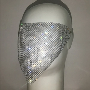 Macro detail of silver mesh mask decorated with sparkling rhinestones on model head