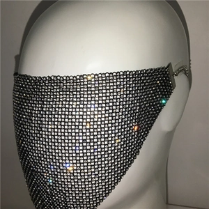 Macro detail of luxury rhinestone mesh mask with shimmering crystals and metal chains