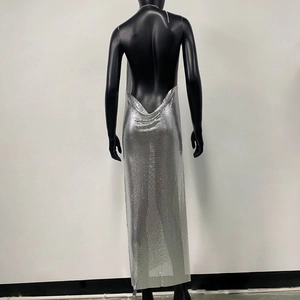 Detail of silver metallic mesh maxi dress featuring backless design with chain halter