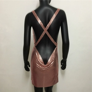 Macro shot of rose gold sequin dress detail with back criss-cross straps and metallic texture