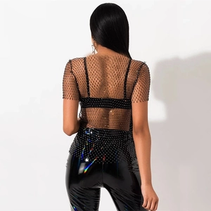 Back view of a black mesh rhinestone short sleeve top with high gloss patent leather pants