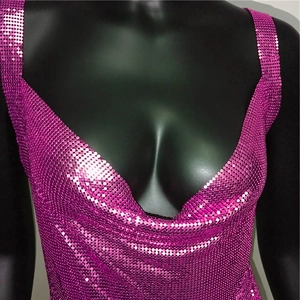 Detailed close-up of fuchsia metallic sequins and deep V-neckline on a party dress