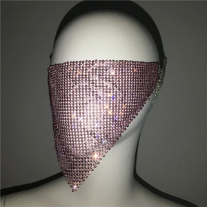 Detailed view of pink rhinestone mesh mask with metallic chains on a display head
