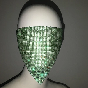 Detail view of green rhinestone face mask with shimmering metal mesh v-shaped design