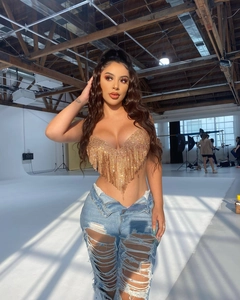Détail d'un crop top doré en strass avec ourlet à franges étincelantes en forme de V
