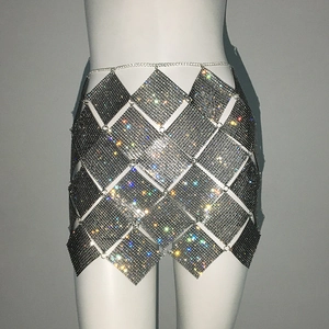 Détail macro de la mini-jupe en strass avec maille métallique et ceinture chaîne