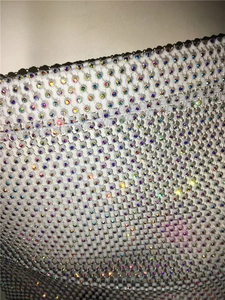 Close-up of white mesh fabric with colorful AB rhinestones and sparkling diamond details