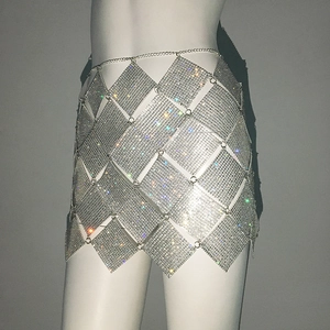Détail de plaques en métal argenté en losange avec strass étincelants sur la mini-jupe