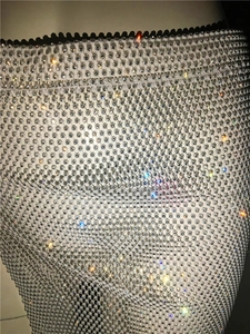 Close-up of sparkling white mesh fabric with dense rhinestones for a sexy party look