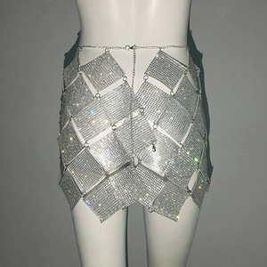 Détails de la maille en strass étincelants et de la chaîne de taille sur la mini-jupe