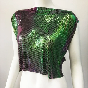 Detailed macro view of iridescent green and purple metallic sequin mesh fabric on top