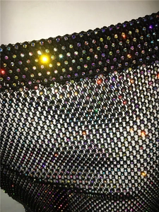 Detailed close-up of mesh fabric featuring shimmering AB iridescent rhinestones on black