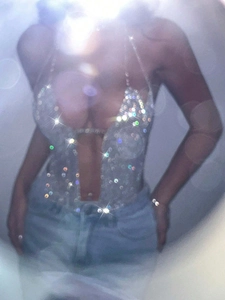 Detailed view of silver sequin halter top with deep V-neck and hollow out waist detail