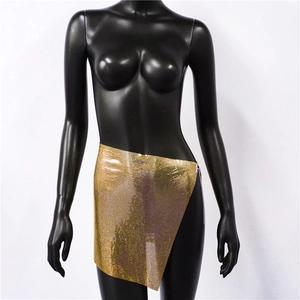 Macro detail of golden metal chainmail mini skirt featuring a reflective mesh texture