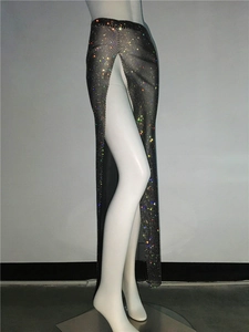 Detail of black mesh dress featuring colorful rhinestones and a high side split design