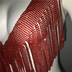 Détail d'un top rouge à paillettes avec col en V et longues franges sur un mannequin