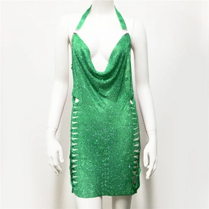 Dettaglio dell'abito verde con strass, scollatura a V profonda e catene metalliche