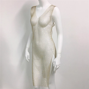 Détail d'une robe en maille strassée dorée avec fente latérale et décolleté en V