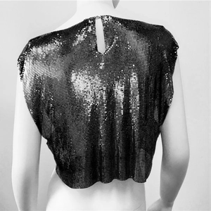 Detail of black sequin crop top featuring metallic mesh texture and halter neck closure