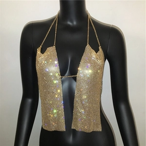 Close-up of golden metal mesh halter top with shimmering rhinestones on black mannequin