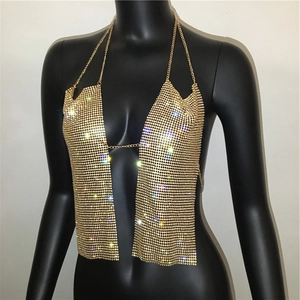 Detail of gold rhinestone mesh halter top featuring metal chains and shimmering finish